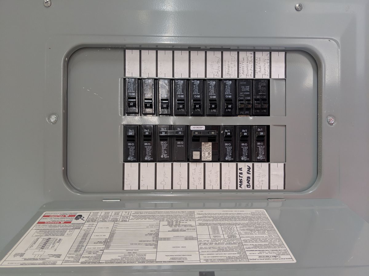 Open residential electrical panel with circuit breakers