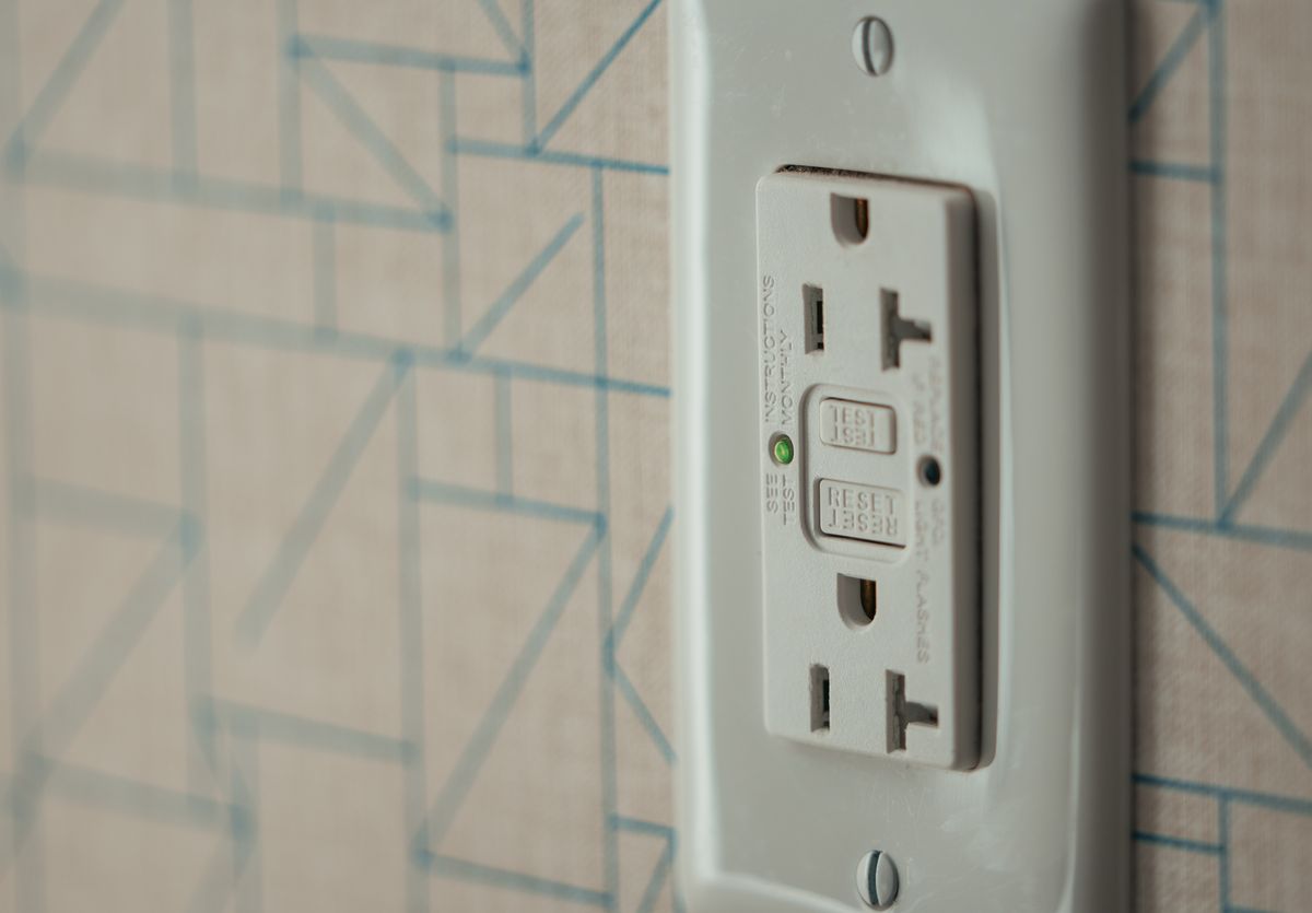 Ground fault circuit interrupter (GFCI) outlet installed on a wall