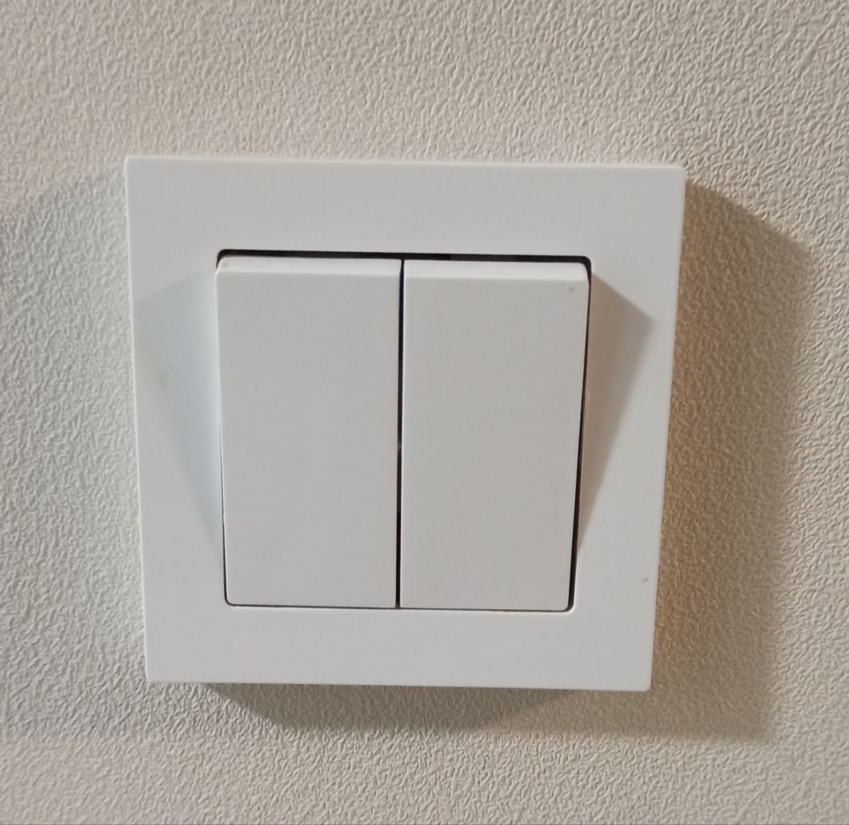White double light switch on a wall, the type we diagnose and repair